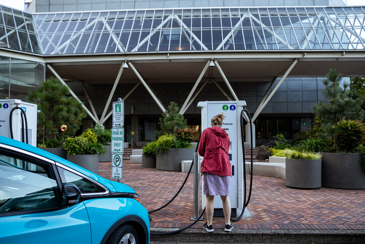woman charging car at urban ev site