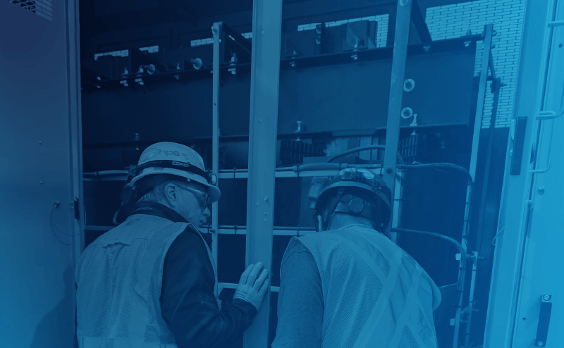 two service agents inspect cast coil transformer